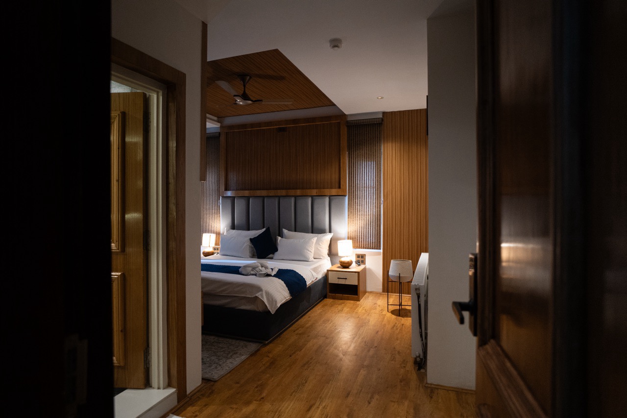 Full view of the Deluxe Room layout showing comfortable seating and mountain view balcony in Pahalgam, Kashmir