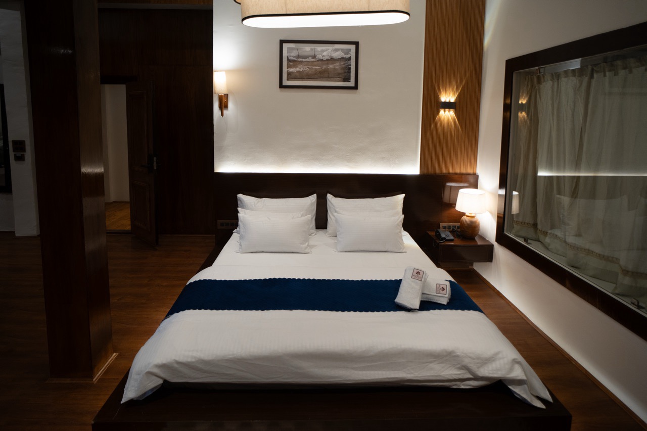 Spacious King Bed setup with fine linens and premium wood finishes in the Premium Studio room